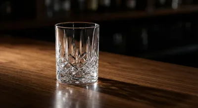 Détail minimaliste d'un verre en cristal sur un comptoir de bar en bois