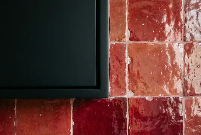 Cuisine rouge et noir : réussir son aménagement - Cuisine rouge et noir : le guide ultime - Cuisine rouge et noir : comment éviter l'effet sombre ? Détail de la texture entre une façade noire et une crédence rouge