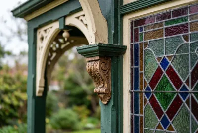 Gros plan sur un porche orné et une fenêtre à guillotine avec vitraux de style victorien.