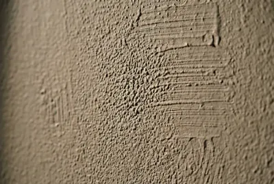 Gros plan sur un défaut de peinture murale avec traces de rouleau.