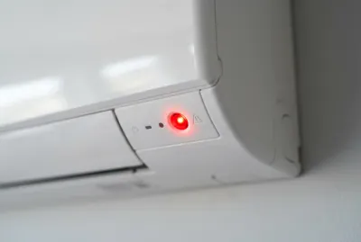 Gros plan d'une climatisation Hitachi en panne avec voyant rouge