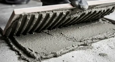 Pose de carrelage avec double couche de colle pour une adhérence renforcée.