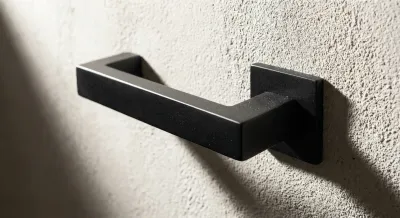 Gros plan minimaliste sur une poignée de porte design pour illustrer le poussant gauche